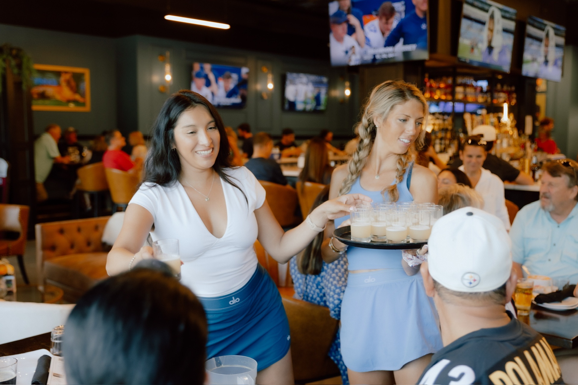 Servers carrying a tray of shots through the lounge