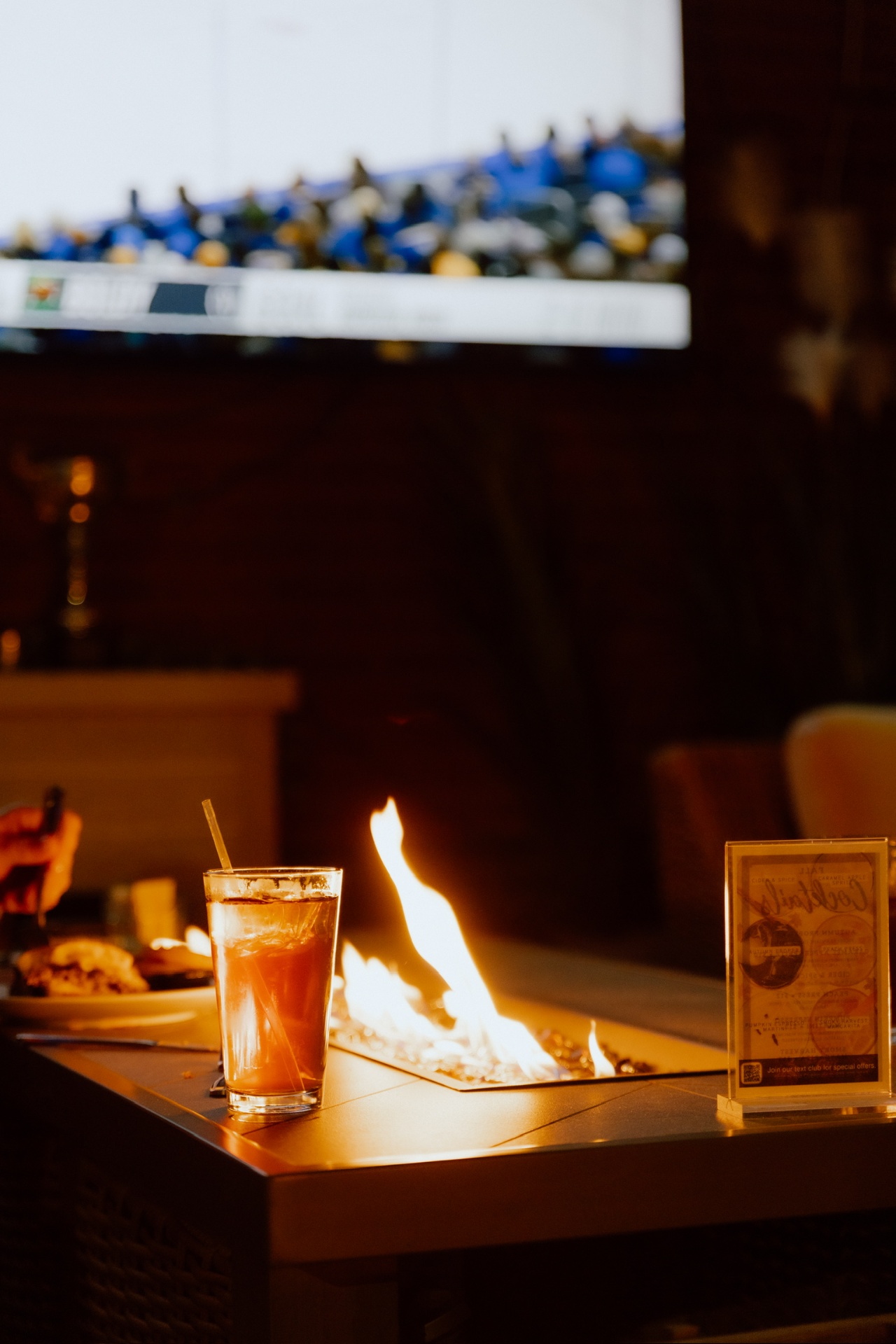 Cocktail by the firepit with the game on