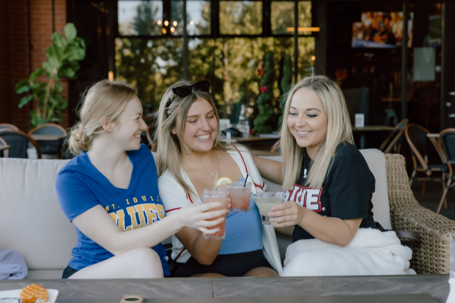 Friends cheers-ing cocktails on the patio
